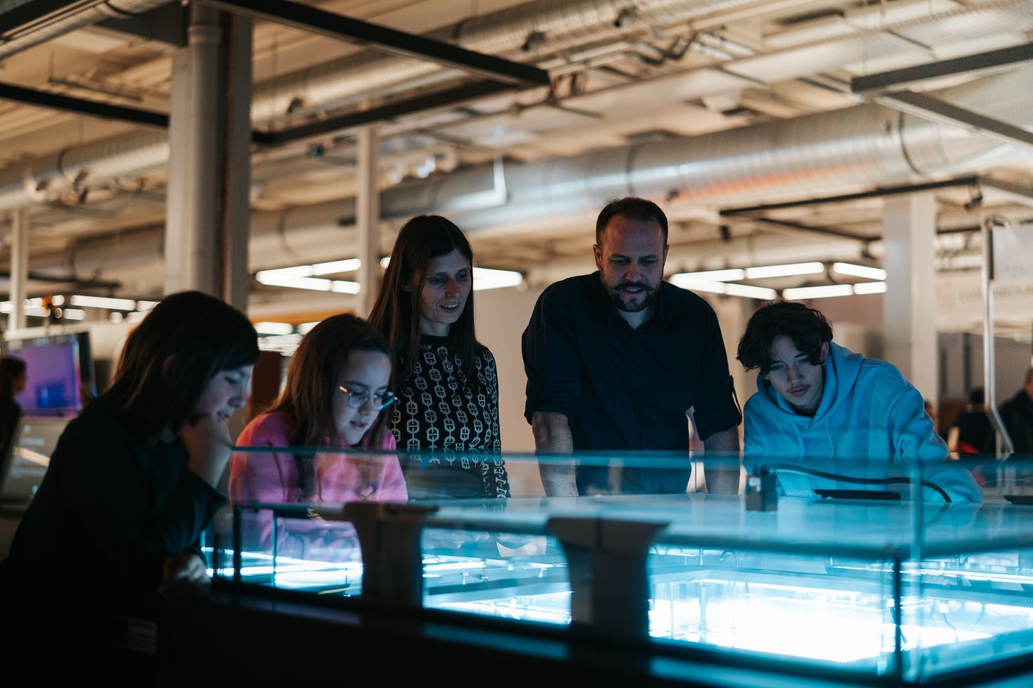 Eine Familie an einer der vielen wissenschaftlichen Experimentstationen im Science Center