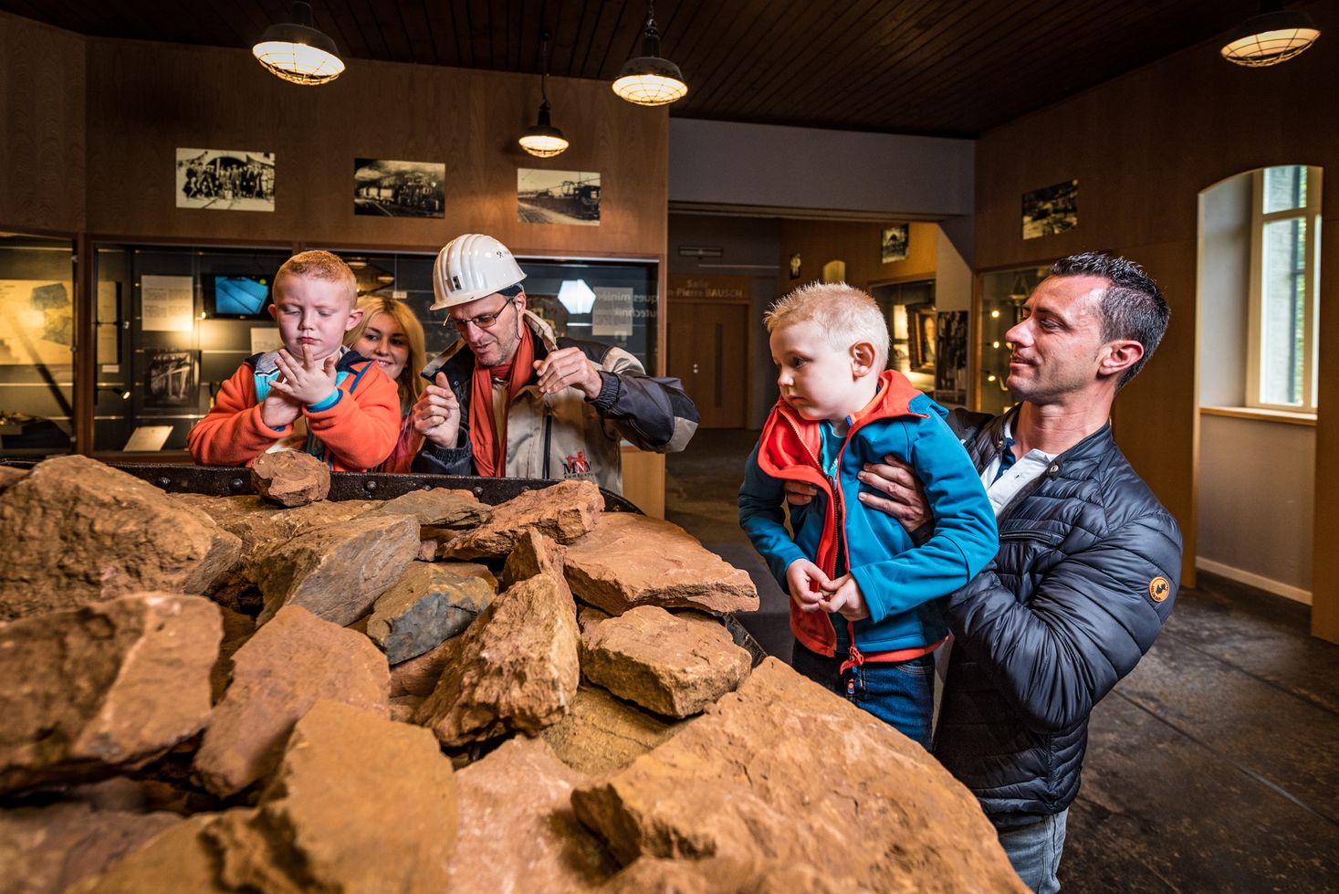 Une famille avec des enfants examine la roche extraite dans le musée