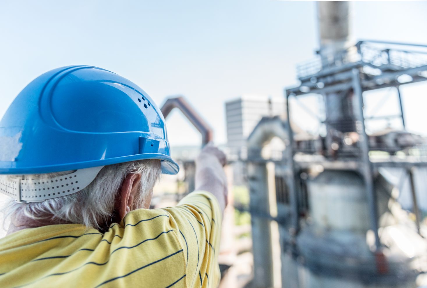 Une homme montrant une partie du haut-fourneau lors d'une visite